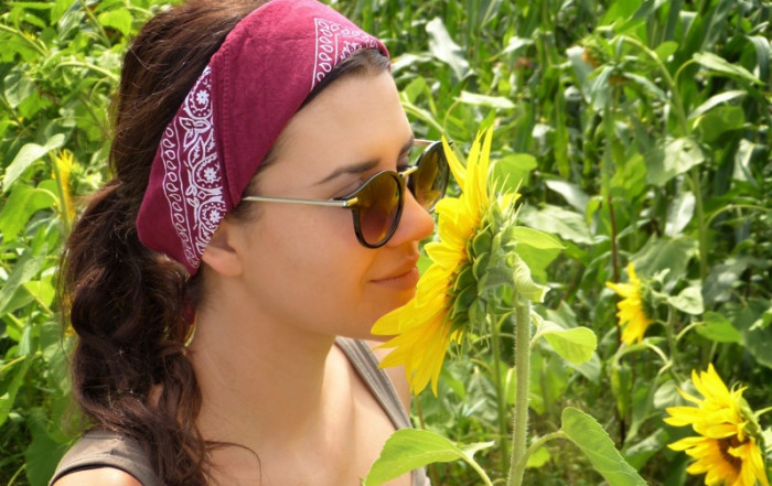 pesticide free flowers - woman sniffs sunflower