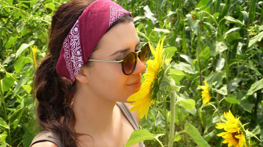 pesticide free flowers - woman sniffs sunflower